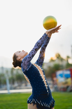 Gymnast holding hands up with ball