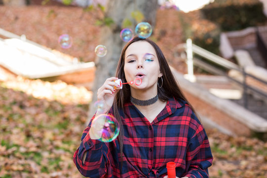Young girl blowing soap bubbles - Powered by Adobe
