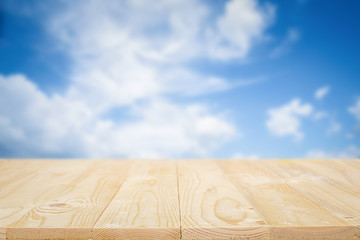 Empty wooden table space platform and blurred sky background for product display montage.