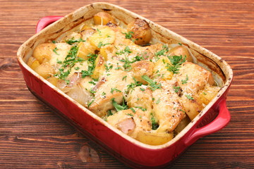 oven baked chicken fillet with potatoes and rosemary on woden table