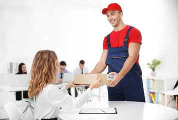 Obraz premium Courier delivering package in office
