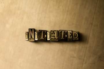 INITIATED - close-up of grungy vintage typeset word on metal backdrop. Royalty free stock illustration.  Can be used for online banner ads and direct mail.