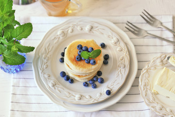 Tasty pancakes with blueberry on kitchen table