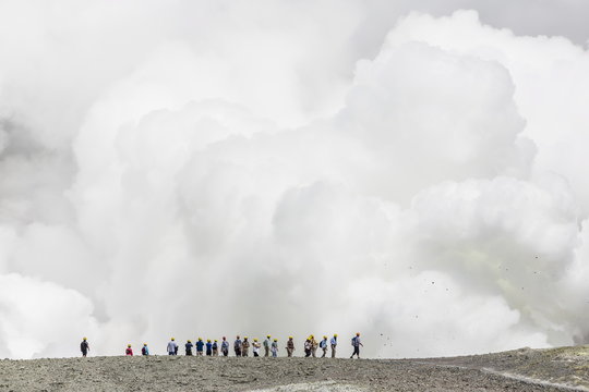 Visitors watching mud being ejected from the caldera floor of an active andesite stratovolcano on White Island, North Island, New Zealand