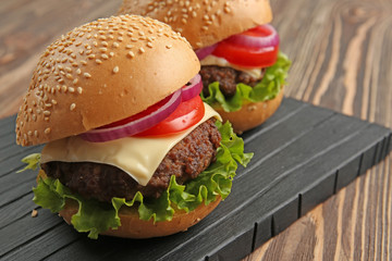 Delicious cheeseburgers on wooden background