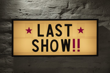 Close-up of Last Show signboard against gray wall