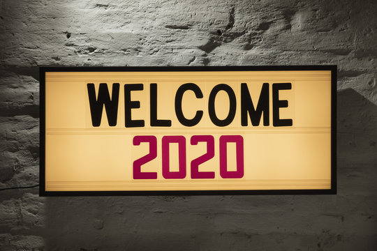 Close-up of Welcome 2020 signboard against gray wall
