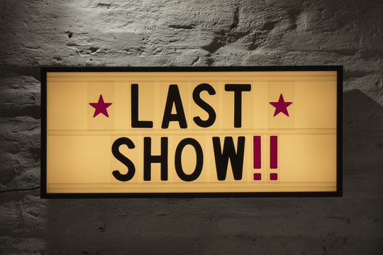 Close-up of Last Show signboard against gray wall