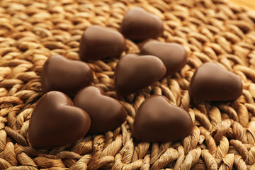 Chocolate hearts on wicker mat background