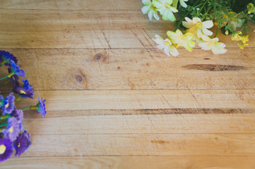Obraz na płótnie Canvas Yellow and Purple Flowers on Wooden Background 