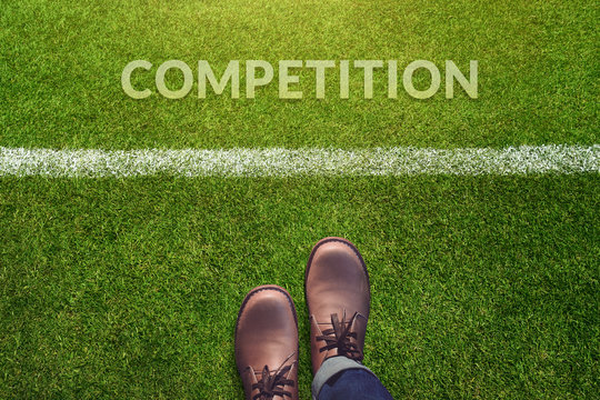 Top view, Male with Leather Shoes Steps forward to a word : Competition on Green Grass Field