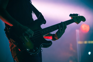 Silhouette of bass guitar player on stage