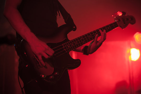 Silhouette of bass guitar player on red