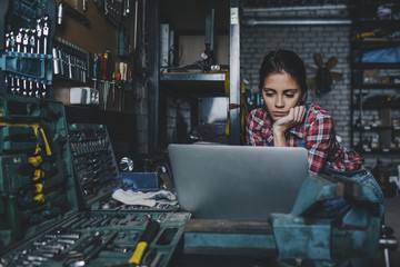 Female mechanic using laptop at workshop