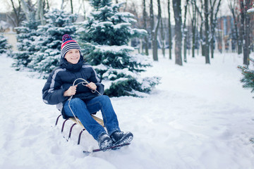 Fototapeta na wymiar Young Man With Sled In Alpine Snow Scene
