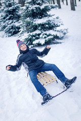 Fototapeta na wymiar Young Man With Sled In Alpine Snow Scene