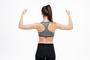 Fototapeta na wymiar Back view portrait of a fitness woman showing her biceps