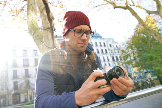 Hipster guy taking pictures in town