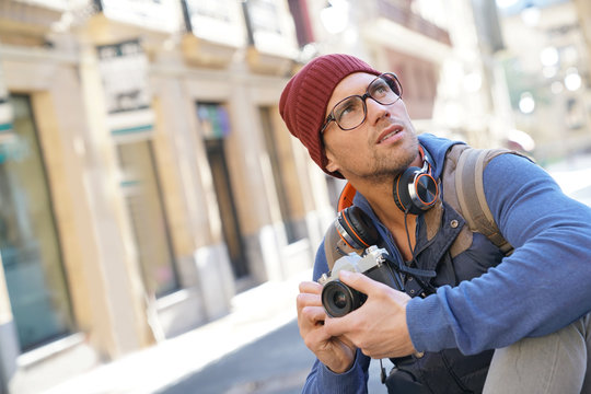 Hipster guy taking pictures in european city