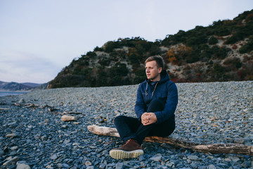 close up of man sitting on the beach and looking forward