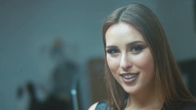 Sexy seductive woman with brown hair blowing smoke from a cigar into a camera, then sending a blow kiss. 4K UHD 60 FPS slow motion