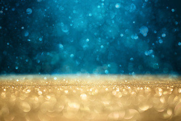 Abstract defocused gold, blue glitter background with copy space