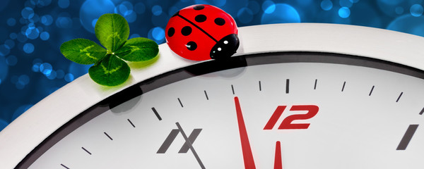 Silvester - Uhr mit Glückssymbolen und Bokeh