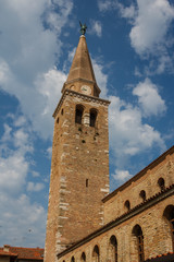 Fototapeta na wymiar Clock tower of the Romanesque church in the center of Grado