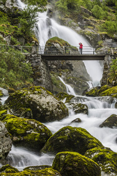 Slow shutter speed silky water of the Olden River and bridge as it flows along Briksdalen, Olden, Nordfjord