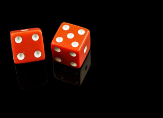 Red dice on black with reflection