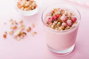 Berry smoothie or milkshake on pink table for dessert, snack and breakfast.
