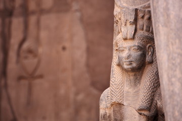 Naklejka premium Starożytna egipska bogini Izyda i Ankh, starożytny symbol życia, wyrzeźbiony w tle starożytnej świątyni. Karnak, Luksor, Egipt