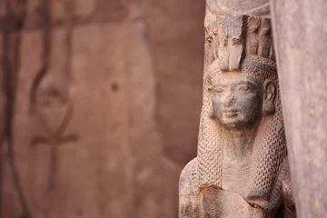  Oude Egyptische godin Isis en Ankh het oude symbool van het leven, uitgehouwen in een oude tempelmuur op de achtergrond. Karnak, Luxor, Egypte © Vladimir Melnik