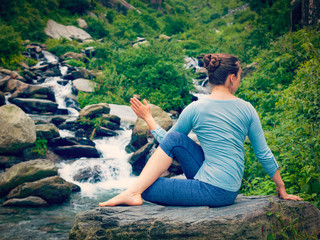 Woman doing Ardha matsyendrasana asana outdoors