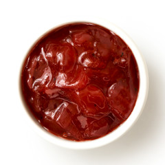Red onion chutney in ceramic bowl isolated on white from above. - obrazy, fototapety, plakaty
