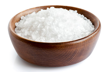 Coarse salt in wooden dish isolated on white.