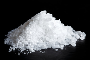 Heap of fine and coarse salt isolated on black. - obrazy, fototapety, plakaty