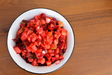 Russian beet salad vinaigrette in rustic bowl on wooden table