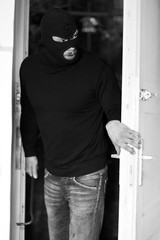 Fototapeta na wymiar Einbrecher mit Maske öffnet die Kellertür