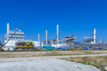 Obraz premium Refinery tower in petrochemical industrial plant with cloudy sky