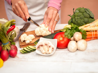 Woman is preparing to cut cauliflower