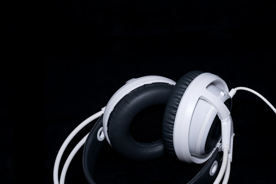 White Headphones for music sound on black, Dark background - Top view with copy space