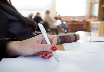 Woman writing notes on lecture