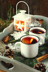 Mulled wine with spices and citrus fruit on vintage tray and bur