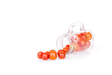 Heap of fresh ripe cherry plum tomatoes in bottle glass on white

