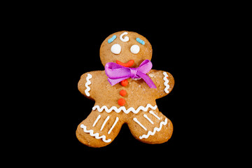 Closeup image of gingerbread man isolated at black background.