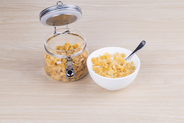 Cornflakes with milk in the white bowl.

