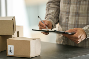 Courier making notes in delivery receipt at table