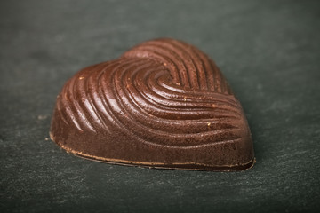 One chocolate candy on a slate background. Toned