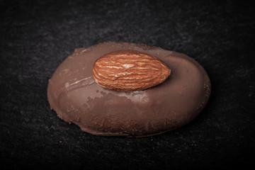 One chocolate candy on a slate background. Toned
